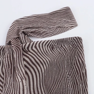 Nahaufnahme von Zebra-Strickstoff mit braunen Streifen und detaillierter Naht
