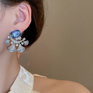 Detailed macro view of luxury blue crystal flower earrings with intricate diamond inlay