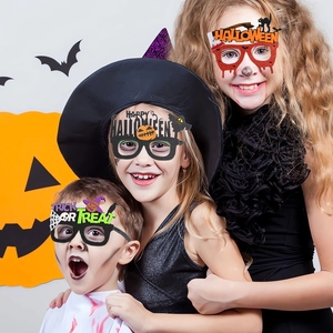 Three children wearing festive Halloween glasses with pumpkins, bats and spiders motifs
