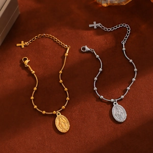 Detail of vintage Madonna and cross pendants on gold and silver stainless steel chains