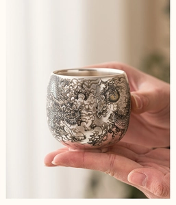 Gros plan détaillé de la gravure de dragon complexe sur une tasse en argent massif 999