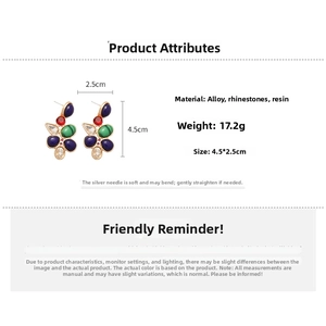 Detailed view of teardrop earrings with silver pins and multicolored rhinestones