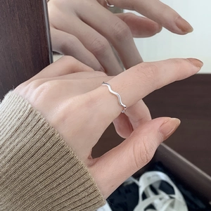 Minimalist 925 sterling silver wavy ring shown on hand with reflective mirror effect