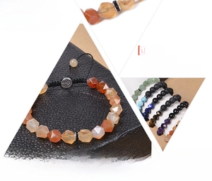 Detail von mehrfarbigen facettierten Natursteinperlen an einem gewebten Armband