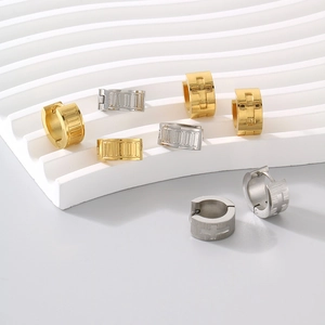 Detail of titanium steel earrings featuring Roman numerals and cross relief patterns