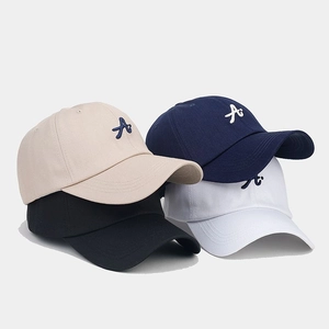 Detailed stack of four baseball caps in beige navy black and white with 3D embroidery
