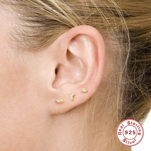 Macro view of gold sterling silver 925 leaf and moon stud earrings set on ear