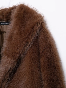 Close-up of brown faux fur texture and branded label on a luxury wool coat