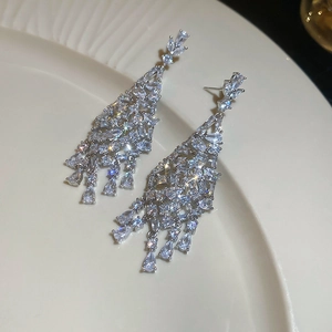 Détail de luxueuses boucles d'oreilles lustres en argent avec pampilles en zircon brillant