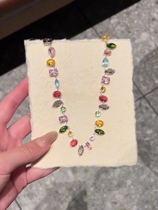 Detailed view of colorful crystal zircon necklace with mixed cut gemstones on silver chain
