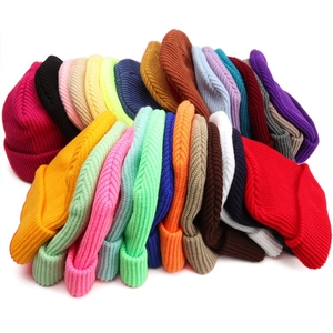 Pile of colorful ribbed knit beanies showing a wide range of available solid color options