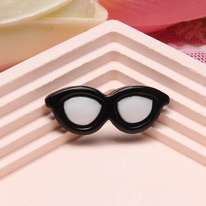 Detail of small black cat-eye resin sunglasses model on a pink geometric stand