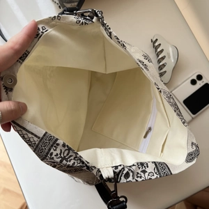 Detail of vintage tote bag interior featuring zipper pocket and magnetic buckle closure