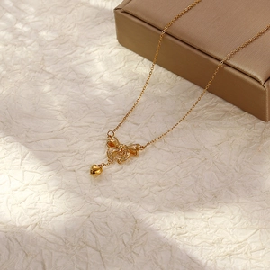 Golden stainless steel bow necklace with heart pendant on a premium jewelry gift box