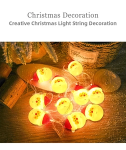 Close-up of Santa Claus LED string lights with warm yellow glow on a wooden surface