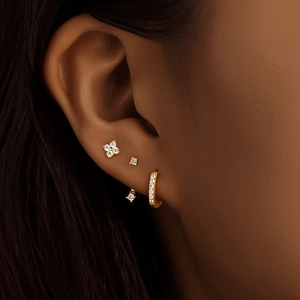 Close-up of gold S925 silver stud earrings set with marquise zircon on a female model