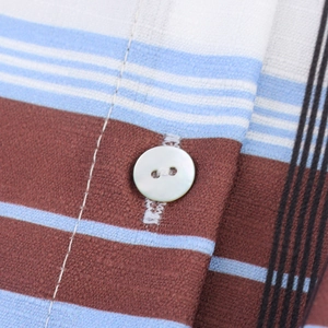Close-up of a plaid shirt dress featuring brown and blue stripes with white button detail