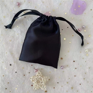 Detail of a small black satin drawstring pouch for jewelry and cosmetic storage