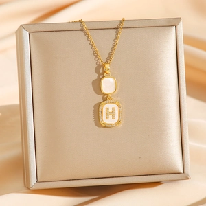 Elegant gold square pendant necklace with H-letter crystals and shell inlay on silk