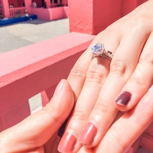 Detailed close-up of a six-prong silver moissanite ring with a brilliant round diamond