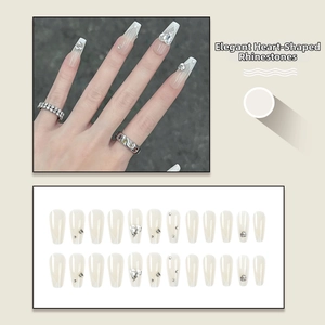 Detail of cream gradient press-on nails with silver heart rhinestones and set layout