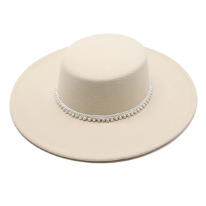 Dettaglio cappello in lana crema con bordo di perle decorative e finitura in feltro