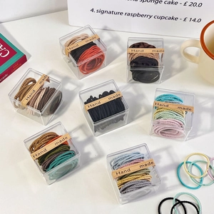Detail view of 8 boxes of colorful spiral elastic hair ties in clear packaging
