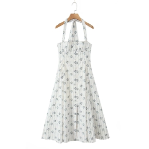 Detail of white halter neck dress featuring blue floral stripes and front buttons