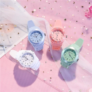 Flat lay of colorful silicone quartz watches in pastel blue, pink, and white on mesh fabric