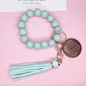 Détail du bracelet en silicone léopard bleu clair avec breloque MAMA et gland