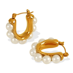 Elegant U-shaped gold earrings with embedded pearls shown against a clean white background