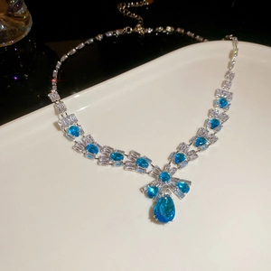 Detailed view of square and teardrop zircon necklace with blue gemstone pendant