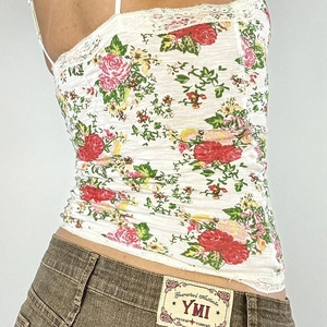 Floral lace camisole in white with multi-color print paired with brown denim jeans