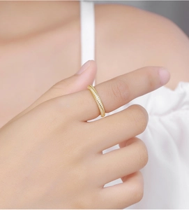 Detailed view of a gold Mobius ring with zircon pavé worn on a finger