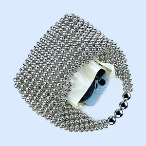 Silver beaded pillow bag showing interior capacity with phone and satin lining