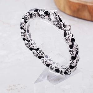 Macro shot of vintage stainless steel punk bracelet with hollow floral engraved links