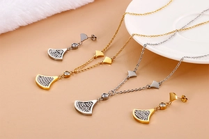 Detailed shot of fan-shaped pendant jewelry set in gold and silver plating with crystals