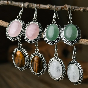 Vintage hollow pink crystal drop earrings hanging on natural wooden branches