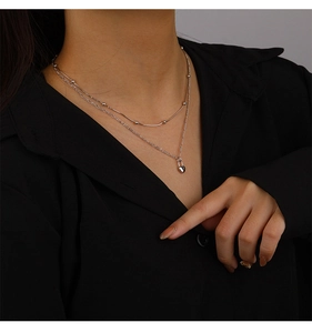 Close-up of double layer 925 sterling silver necklace with heart pendant and metal beads
