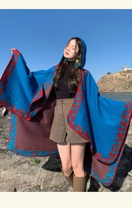 Detail of hooded blue poncho with red ethnic patterns for outdoor travel and warmth