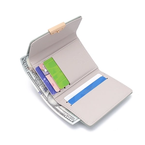 Detail of the open tri-fold wallet with cash compartments and golden hardware buckle