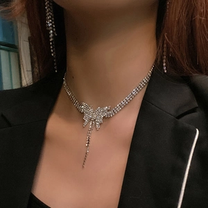Elegant rhinestone butterfly tassel necklace and earring set on model in black suit