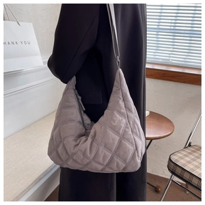 Detailed view of grey quilted crossbody bag showing soft nylon texture and stitching