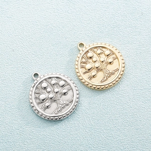 Golden and silver stainless steel Tree of Life circular pendants on light blue background