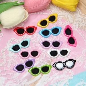 Flat lay of colorful resin cat-eye mini sunglasses for DIY crafts and doll accessories