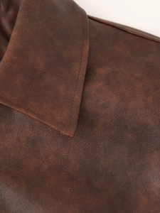 Gros plan détaillé du col en cuir vintage et des coutures sur une veste marron rétro