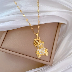 Detailed close-up of a luxury gold-plated bear pendant with sparkling crystals on satin