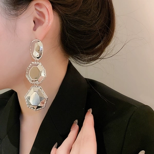 Gros plan détaillé de boucles d'oreilles longues argentées portées par un mannequin