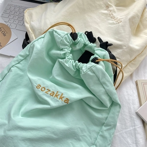 Nahaufnahme von Nylon-Rucksäcken in Mintgrün und Cremeweiß mit Logo-Stickerei