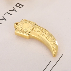 Macro di un ciondolo a dente di lupo in oro acciaio inossidabile con motivi a sbalzo